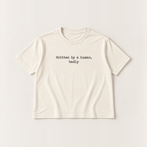 Written by a human, badly slogan tee, natural Core Tee, black typewriter print