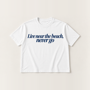 Live near the beach, never go slogan tee, white Core Tee, navy italic serif print